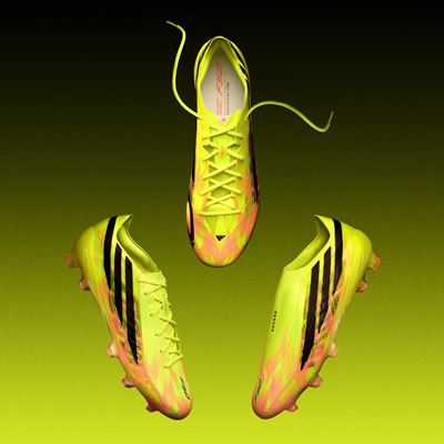 Three neon yellow and pink soccer cleats with black stripes displayed against a gradient yellow to black background, showing different angles including top, side, and bottom views.