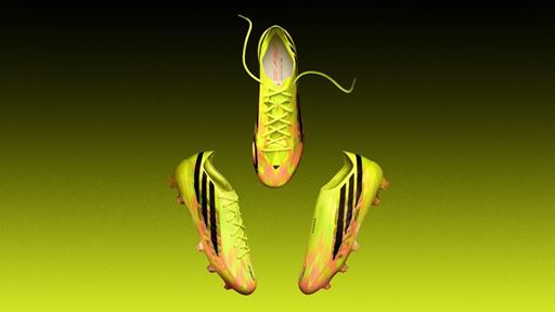 Three neon yellow and pink soccer cleats with black stripes displayed against a gradient yellow to black background, showing different angles including top, side, and bottom views.